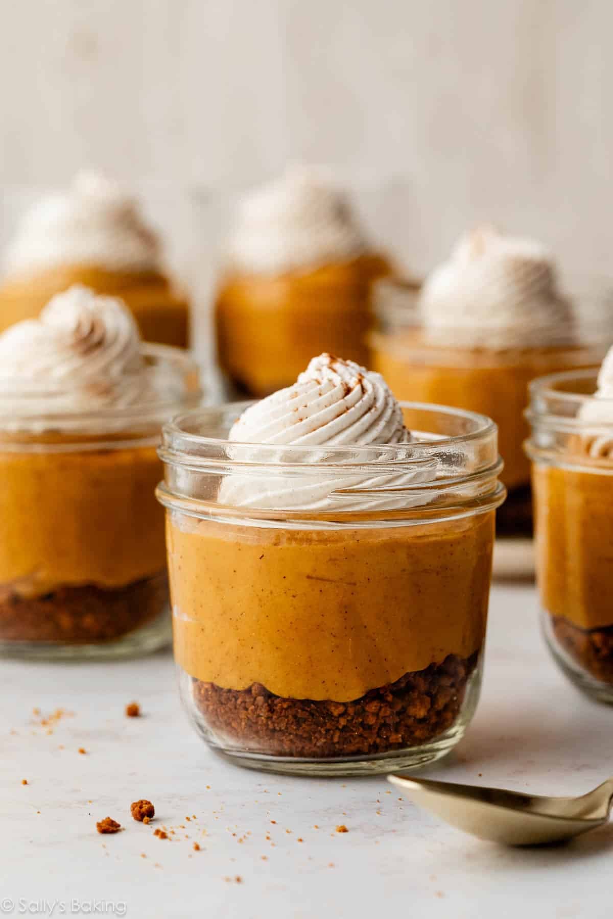 pumpkin pie jars layered with cookie crust and whipped cream.