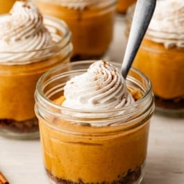pumpkin pie in a jar with whipped cream.