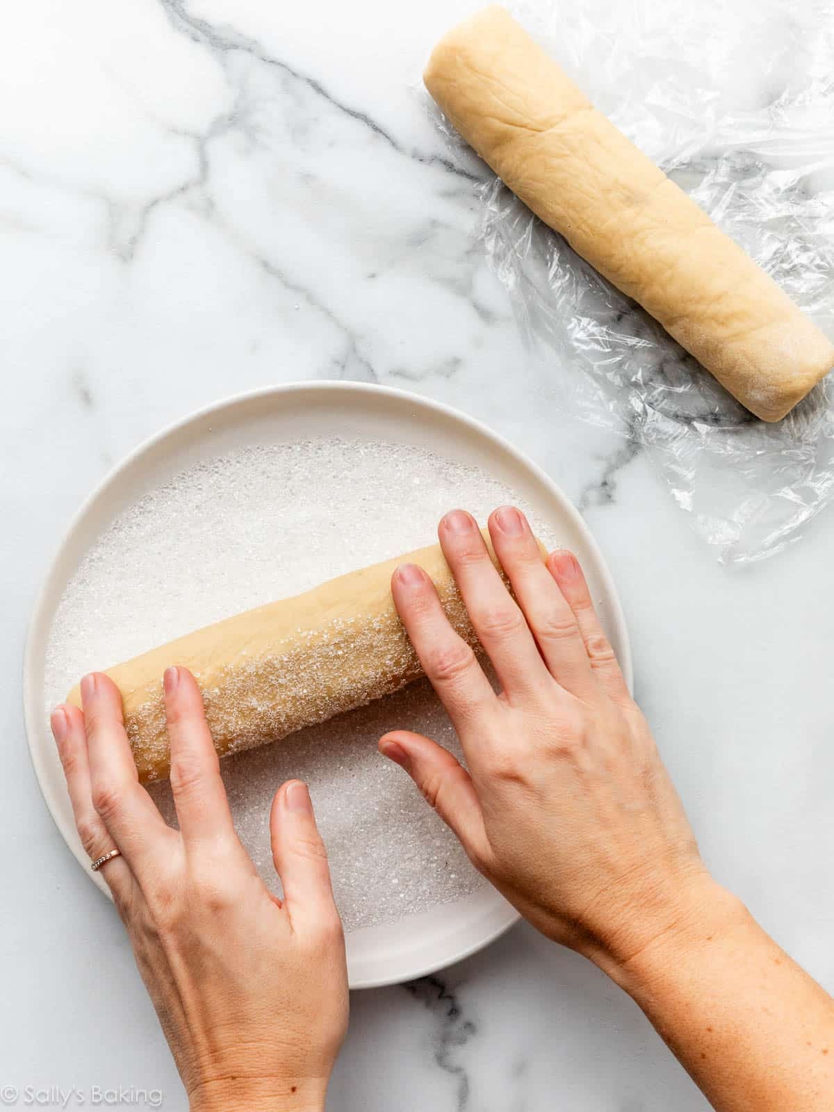 hands rolling logs of dough.