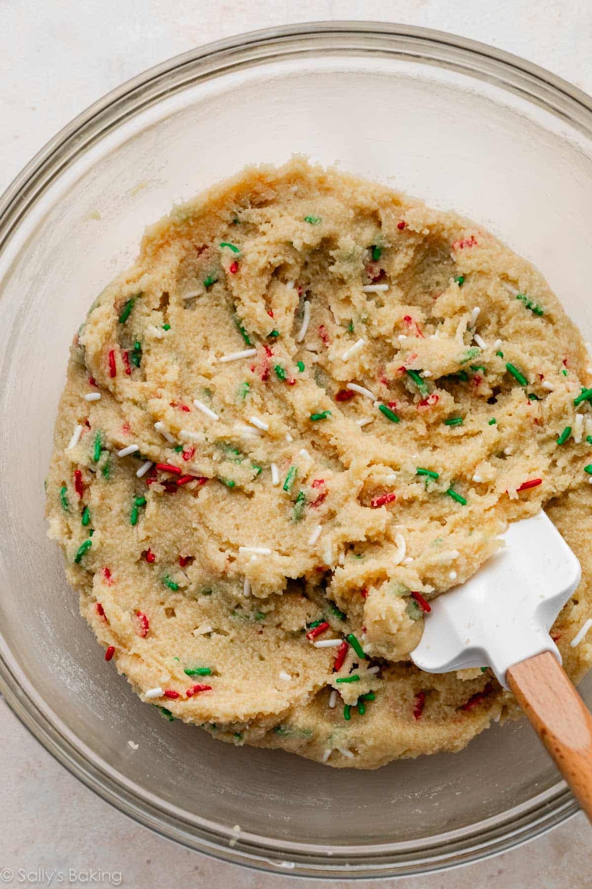 cookie dough with Christmas sprinkles in glass bowl.